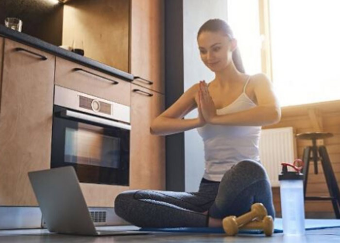 Women doing virtual yoga from home.